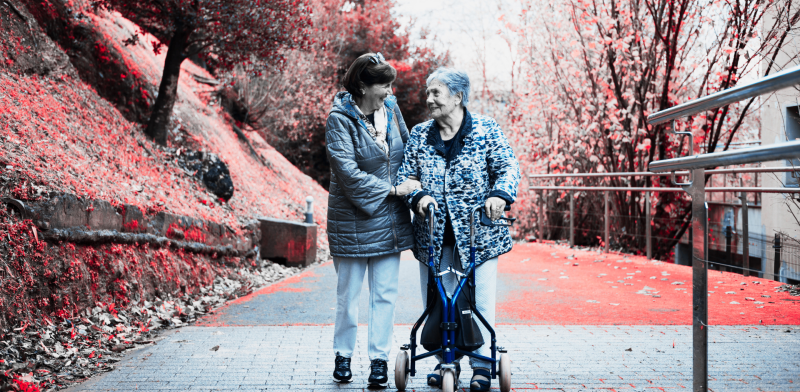 Imagen de dos mujeres, posiblemente madre e hija, que pasean y se sonríen